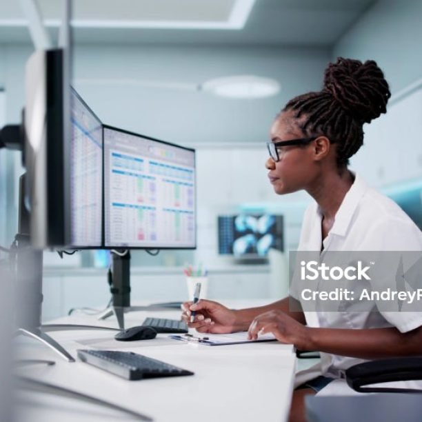 Hospital Doctor Using Spreadsheet For Billing Codes On Desktop